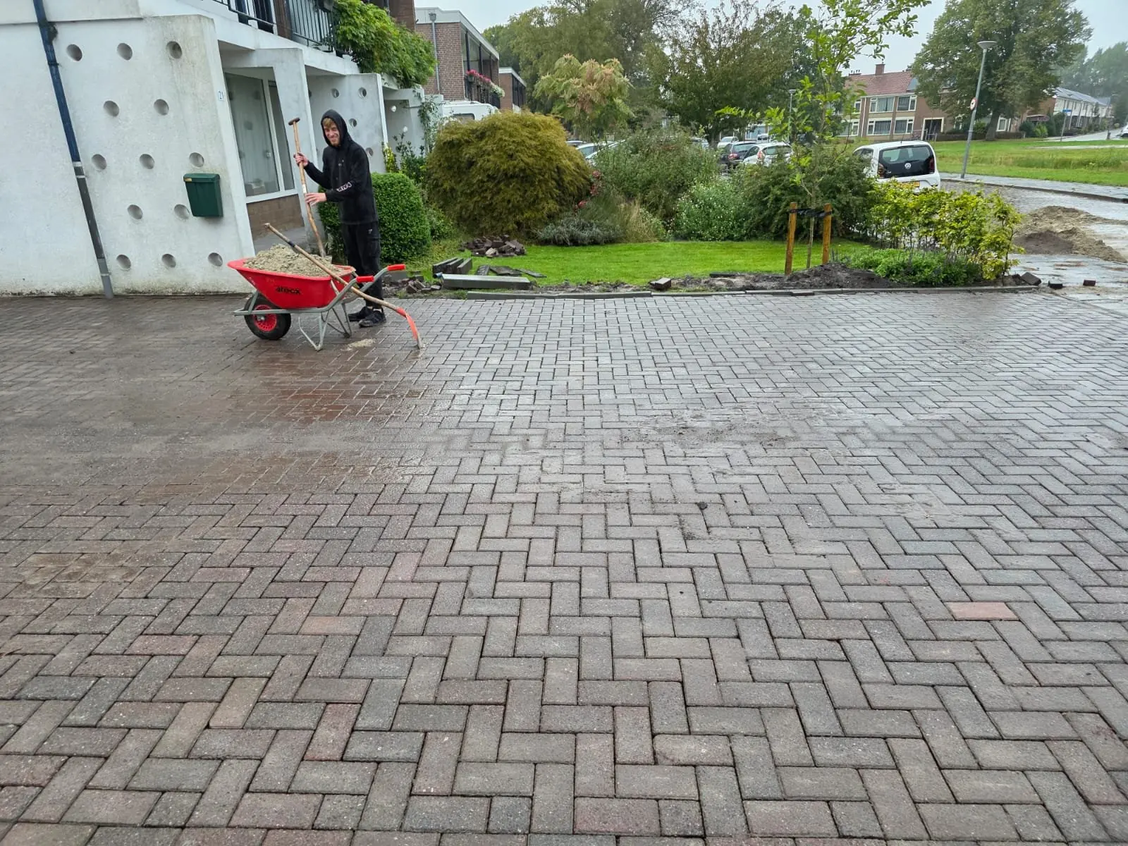 Oprit van grijsrode klinkers in keperverband voor een rijtjeshuis